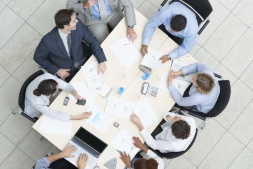 Corporate staff sat at a table negotiating.